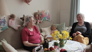Die Hospizbegleiterin Gabi Murr sitzt zusammen mit einer älteren Frau im Wohnzimmer.