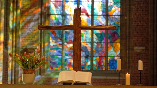 Ein Kreuz steht im Altarraum der Kirche Unser Lieben Frauen in Bremen mit Glasfenstern des französischen Malers Alfred Manessier.
