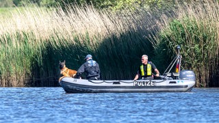Polizisten suchen mit einem Motorboot nach dem verschwundenen Arian.