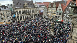 Menschenmenge auf dem Bremer Marktplatz, in der Mitte der Roland. 