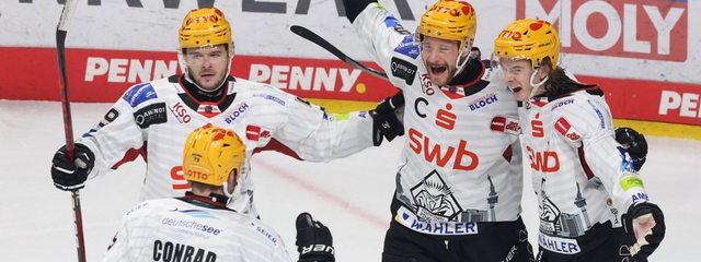Eishockey-Spieler um Jan Urbas und Colt Conrad von den Fischtown Pinguins bejubeln gemeinsam überschwänglich einen Treffer auf dem Eis.