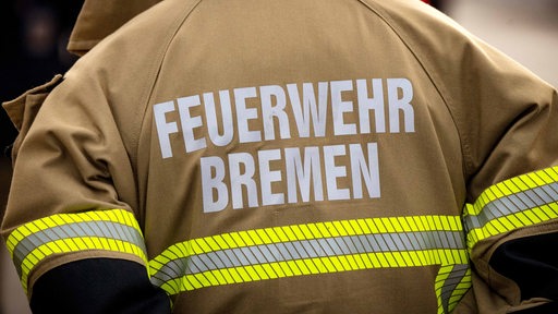 Eine Einsatzkraft der Feuerwehr Bremen ist von hinten zu sehen