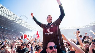 Fans des Fußball-Klubs FC St. Pauli haben nach dem Aufstieg den Rasen gestürmt und feiern ausgelassen