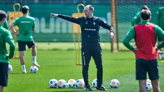 Werder-Trainer Ole Werner gibt seinen Spielern auf dem Trainingsplatz mit dem ausgestreckten rechten Arm die Richtung vor.