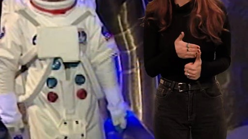 Eine Frau steht neben einem Astronauten.
