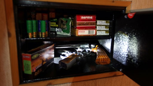 Revolver und Pistolen liegen in einem Waffenschrank.