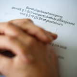 Eine Frauenärztin hat ihre Hände auf der Beratungsbescheinigung gemäß Paragraph 7 Schwangerschaftskonfliktgesetz und Paragraph 219 Strafgesetzbuch gelegt.