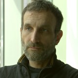 André Aden, Mitarbeiter der Mobilen Beratung gegen Rechtsextremismus in Bremen und Bremerhaven, blickt skeptisch an der Kamera vorbei.