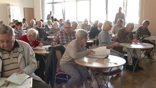 Menschen sitzen während eines Gruppenkurses in einem Raum der Bremer Bibliothek