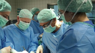 Mehrere Chirurgen im Operationssaal während einer Operation.