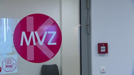 Das Logo der Medizinischen Versorgungszentren an einer Glastür.