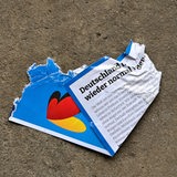 In einer Halle einer Entsorgungsfirma liegt auf dem Fußboden ein zerrissener AfD-Flyer aus dem Bundeswahlkampf.