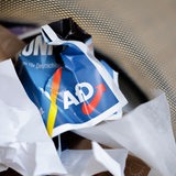 Ein Flyer der AfD liegt zerknüllt in einem Mülleimer.