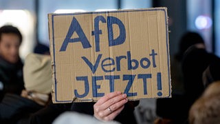 Auf einem Pappschild steht die Aufschrift "AfD Verbot jetzt!"