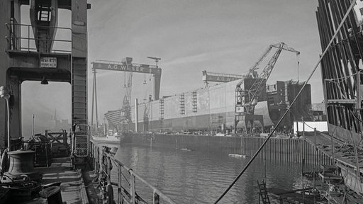 Ein altes Foto von der AG Weser. Auf der Werft ist ein großes Schiff im Bau.