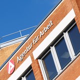 Das Logo der Agentur für Arbeit hängt an einem Gebäude.