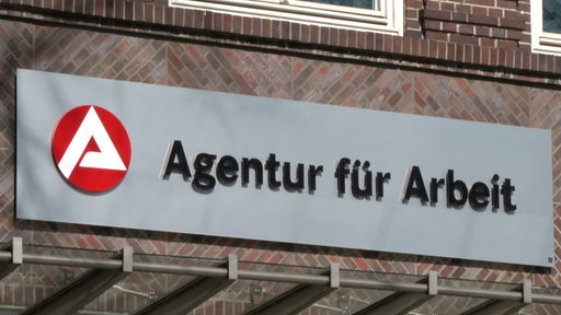 Das Schild der Agentur für Arbeit an einer Fassade.