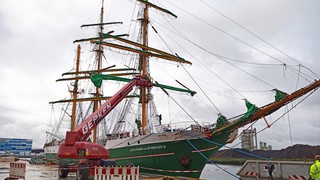 Die "Alexander von Humboldt II" liegt im Dock. Davor ein Kran mit Begutachtern.