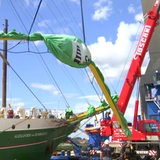 Eine Rahe der "Alexander von Humboldt II" wird von einem Kran in die Höhe gehoben.