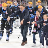 Der Eishockey-Manager der Fischtown Pinguins miot Spielern udn Kindern auf dem Eis