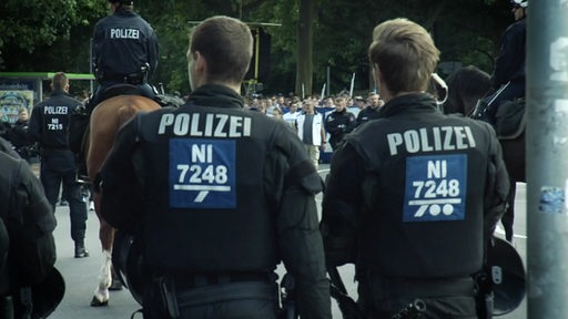 Zwei Polizisten in Uniform in Einsatz von hinten. 