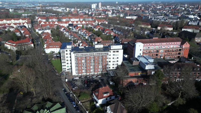 Aus der Luft sind zwei mehrstöckige Gebäude in einem Stadtgebiet zu sehen.