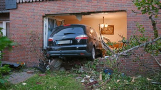 Auto steht zur Hälfte in einem Wohnhaus, Fenster zerstört