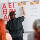 Eine Frau schreibt etwas an eine Tafel
