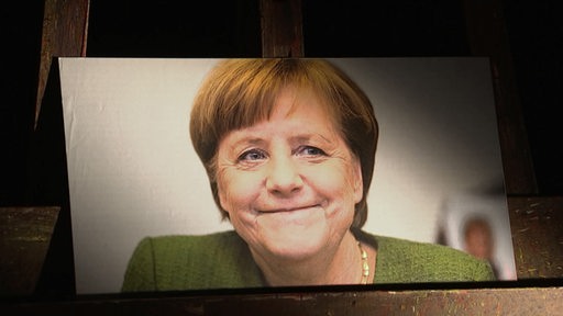 Ein Portrait von der Ex Bundeskanzlerin Angela Merkel auf einer Staffelei. 