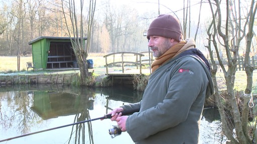 Ein Angler steht an einem Angelteich in Osterholz-Scharmbeck.