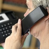 Eine Frau telefoniert mit einem Festnetztelefon (Archivbild)