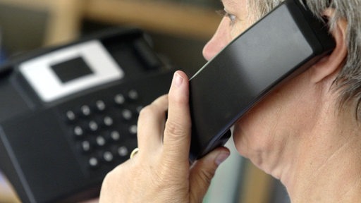 Eine Frau telefoniert mit einem Festnetztelefon (Archivbild)