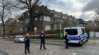 Polizisten stehen vor einem abgesperrten Gebäude am Bremer Osterdeich.