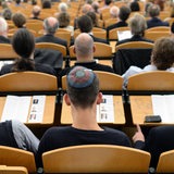 In einem vollbesetzten Hörsaal sitzen sieht man 3 Studierende mit einer Kippa auf dem Kopf.