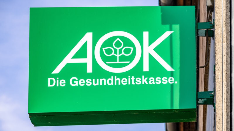Logo der Krankenkasse AOK auf einem Schild