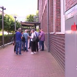 Vor dem Jobcenter sind mehrere Menschen versammelt.
