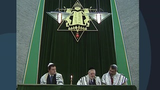 Ein Archivbild aus dem Jahr 1995. Drei Rabbiner stehen in einer Synagoge an einem Altar unter einem Davidstern.