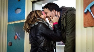 Eine Frau und ein Mann küssen sich durchs Fenster - Filmszene "Auf einmal war es Liebe"