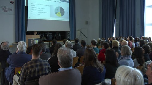 Zu sehen ist ein gefüllter Saal indem ein Vortrag zur Bremer Armutskonferenz gehalten wird