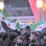 Menschen stehen mit syrischen Fahnen auf der Bremer Bürgerweide.