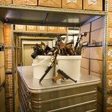 Pistolen stehen zwischen Regalen mit Kartons in einer Asservatenkammer.