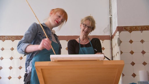 Maike Evers-Schmidt in einem Atelier mit Kunsttherapeutin Halka Breyhan.