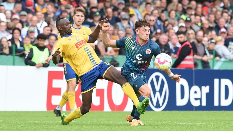 St.Paulis Philipp Treu kämpft gegen Delmenhorst Ousman Touray um den Ball.