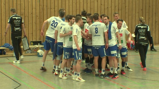 Das Hanballteam der ATSV Habenhausen steht in einem Huddle zusammen am Spielfeldrand.