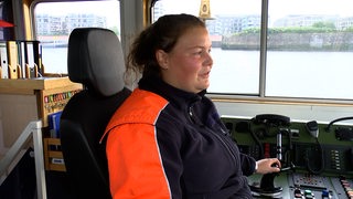 Azubi Lena Schewe steuert ein Binnenschiff.