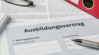 Ein Ausbildungsvertrag liegt auf einem Tisch.