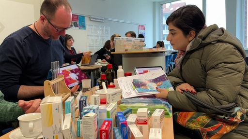 Eine Schülerin informiert sich auf der Ausbildungsbörse an einem Stand mit Pharmazeutischen Mitteln.