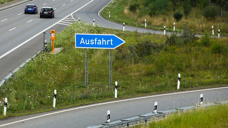Schild mit der Aufschrift ' Ausfahrt ' an einer Autobahnausfahrt.