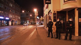 Drei Polizisten beim kontrollieren der nächtlichen Ausgangssperre im Bremer Viertel. 