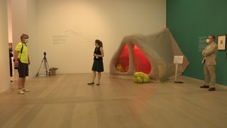 Ein Austellungsraum in der Kunsthalle zur aktuellen Austellung "Smell it". In einer Ecke steht eine große Nachbildung einer menschlichen Nase und Besucher sehen sich im Raum um.